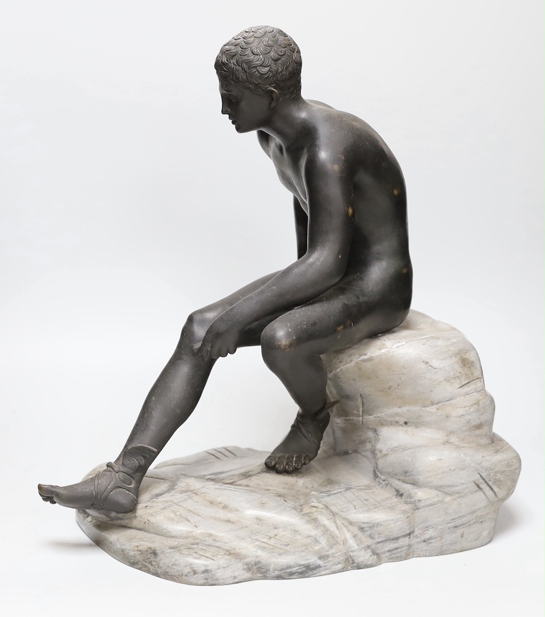 After the Antique, a late 19th century bronze figure of Mercury, seated on a grey marble naturalistic rocky base, 41cm high